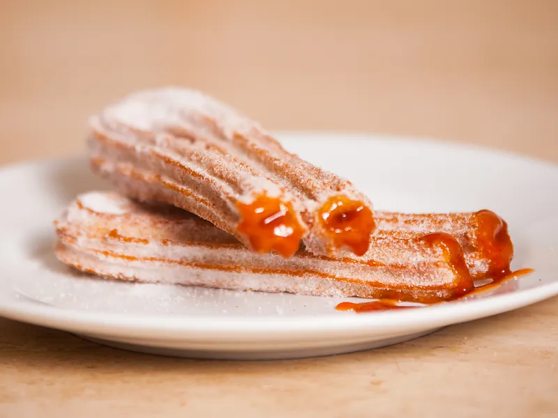 Churros rellenos abiertos con el relleno de guayaba saliendo