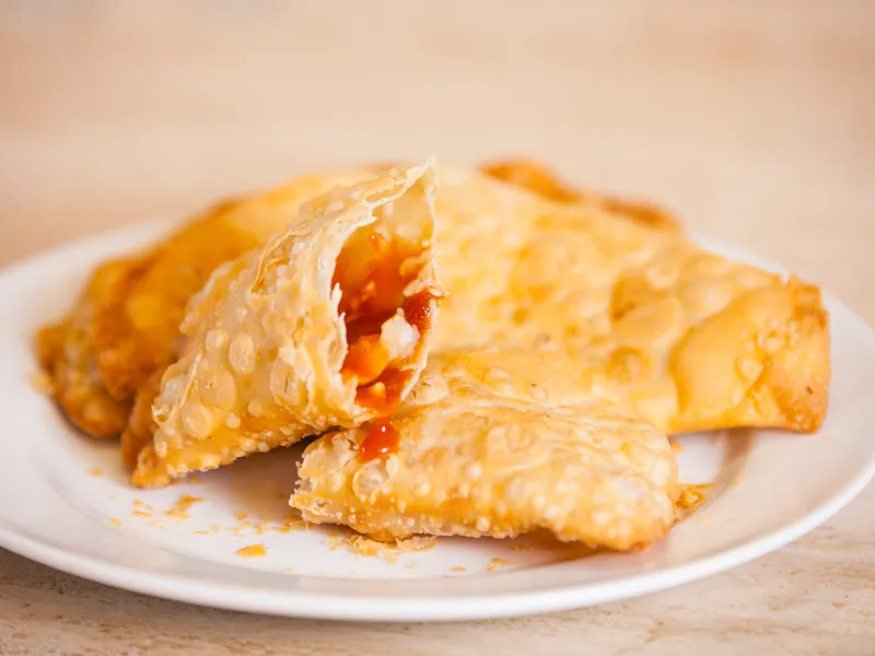 Una empanada abierta con relleno de guayaba y queso