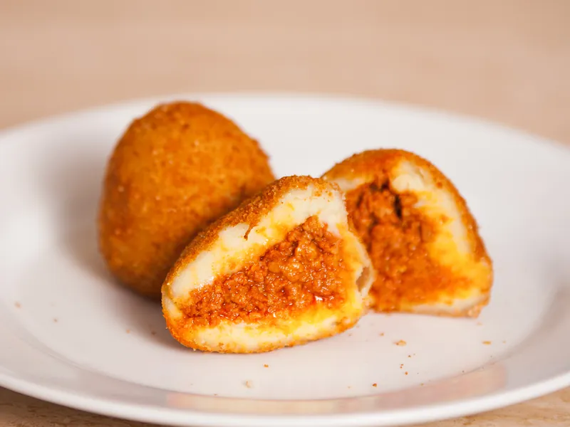 Una papa rellena abierta con su relleno de carne sazonada