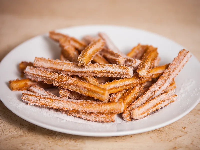 Un plato de churros tradicionales cubiertos de azúcar